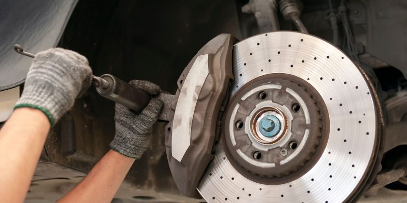 Mechanic repairing a car with replace brake disc and pads